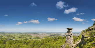 Rock pillar (the Devil's Chimney) in the foreground and extensive views from the Cotswold escarpment beyond